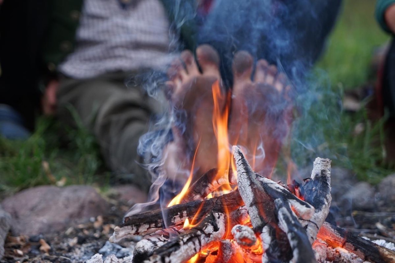 Füße wärmen sich am Lagerfeuer auf dem Kursgelände